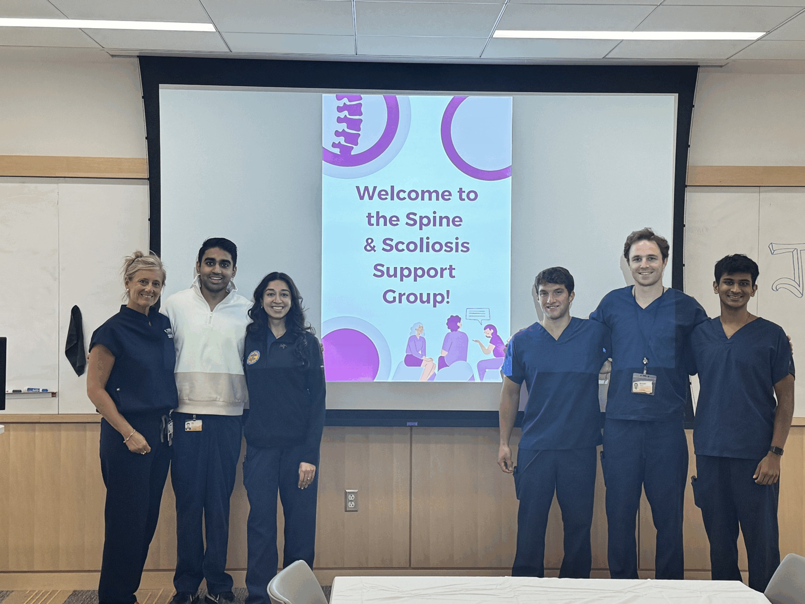 SCOLI team members welcoming attendees at a previous Spine and Scoliosis Support Group meeting